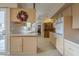 Kitchen with an island, light wood cabinets and a view into dining area at 10027 W Concord Ave, Sun City, AZ 85351