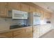 Kitchen with light wood cabinets, a cooktop and a built in oven at 10027 W Concord Ave, Sun City, AZ 85351