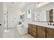 Luxurious bathroom with soaking tub, double sinks, wood cabinets, and large mirrors creating a spa-like retreat at 11441 E Utah Ave, Mesa, AZ 85212