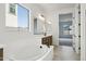 Luxurious bathroom featuring a soaking tub, double vanity, and stylish fixtures with a view to a carpeted room at 11441 E Utah Ave, Mesa, AZ 85212