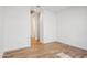 An empty bedroom featuring wood-style floors, white walls, and ample natural light streaming through the open doorway at 11441 E Utah Ave, Mesa, AZ 85212