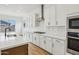 Well-lit kitchen with white cabinetry, quartz countertops, stainless steel appliances, and a functional layout at 11441 E Utah Ave, Mesa, AZ 85212