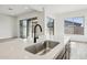 Modern kitchen island with stainless steel sink and black faucet, complemented by large sliding glass doors at 11441 E Utah Ave, Mesa, AZ 85212