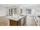 Open-concept kitchen featuring island with sink and stainless steel appliances, seamlessly connecting to the living area at 11441 E Utah Ave, Mesa, AZ 85212