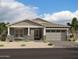 Single-story home with gray siding, stone accents, and a two-car garage at 11464 E Utah Ave, Mesa, AZ 85212