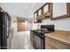 Kitchen with wood cabinets and black appliances at 12611 W Gable Hill Dr, Sun City West, AZ 85375