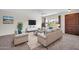 Living room with beige sofas, a coffee table, and a large window at 12611 W Gable Hill Dr, Sun City West, AZ 85375