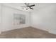 Simple bedroom with ceiling fan and large window with blinds at 13407 N Primrose St, El Mirage, AZ 85335