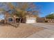 House exterior with a two-car garage and mature tree at 13407 N Primrose St, El Mirage, AZ 85335