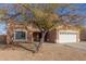 House exterior with a two-car garage and mature tree at 13407 N Primrose St, El Mirage, AZ 85335