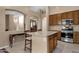 Kitchen boasts an island, wood cabinets, and stainless steel appliances at 14248 W Edgemont Ave, Goodyear, AZ 85395