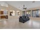 Bright living room featuring a comfortable gray sofa and tile flooring at 14248 W Edgemont Ave, Goodyear, AZ 85395