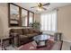 Cozy living room featuring a brown leather sofa, coffee table, and decorative mirrors at 14248 W Edgemont Ave, Goodyear, AZ 85395