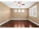 Bedroom featuring dark hardwood floors, a ceiling fan, neutral walls, and three windows with shutters at 15432 W Corrine Dr, Surprise, AZ 85379