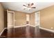 Bedroom featuring dark wood floors, two closets, access to a bathroom, and a ceiling fan at 15432 W Corrine Dr, Surprise, AZ 85379