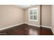 Bedroom featuring hardwood floors, neutral walls, and a large window with shutters at 15432 W Corrine Dr, Surprise, AZ 85379