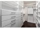 Walk-in closet featuring custom built-in shelving, drawers, and hanging rods for optimal organization at 15432 W Corrine Dr, Surprise, AZ 85379