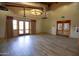 A spacious empty room with luxury vinyl flooring and double doors offering natural light at 15432 W Corrine Dr, Surprise, AZ 85379