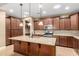 Gourmet kitchen features dark wood cabinets, granite countertops, stainless steel appliances, and a large center island at 15432 W Corrine Dr, Surprise, AZ 85379