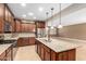 Gourmet kitchen features dark wood cabinets, granite countertops, stainless steel appliances, and a large center island at 15432 W Corrine Dr, Surprise, AZ 85379