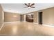 Expansive living room with wood-look tile flooring, neutral walls, and an open floor plan flowing into the kitchen at 15432 W Corrine Dr, Surprise, AZ 85379