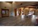 A large meeting room with wood look flooring, wooden doors, and a long table with red chairs at 15432 W Corrine Dr, Surprise, AZ 85379