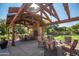 Inviting outdoor seating area with a fireplace and wooden pergola in a shared community space at 15432 W Corrine Dr, Surprise, AZ 85379