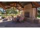 Relaxing outdoor patio area with a brick fireplace and shaded seating for community gatherings at 15432 W Corrine Dr, Surprise, AZ 85379