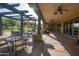 Inviting outdoor patio space with overhead beams, ceiling fans, and ample seating for enjoying the fresh air at 15432 W Corrine Dr, Surprise, AZ 85379