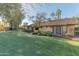 Backyard view of home showcasing green lawn and trees at 17045 N 58Th Way, Scottsdale, AZ 85254