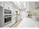 Modern white kitchen with stainless steel appliances and quartz countertops at 1825 W Seldon Way, Phoenix, AZ 85021