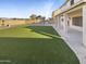 Spacious backyard with artificial turf and a covered patio at 2014 N 94Th Gln, Phoenix, AZ 85037