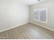 Spacious bedroom with wood-look floors and large window at 2014 N 94Th Gln, Phoenix, AZ 85037