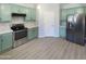 Modern kitchen with light green cabinets, stainless steel appliances, and white quartz countertops at 2014 N 94Th Gln, Phoenix, AZ 85037