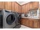 Laundry room with washer, dryer, and wooden cabinets at 20334 E Colt Dr, Queen Creek, AZ 85142