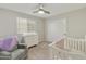 Bedroom with crib, dresser, and comfortable armchair at 20409 E Escalante Ct, Queen Creek, AZ 85142