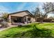 This backyard features green grass, mature landscaping, a covered patio and blue skies at 21804 N 38Th Pl, Phoenix, AZ 85050