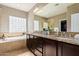 Luxurious bathroom featuring a soaking tub, dual sinks, and decorative tile work at 21804 N 38Th Pl, Phoenix, AZ 85050