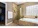 Elegant bathroom with a glass-enclosed shower, soaking tub, and stylish tile accents at 21804 N 38Th Pl, Phoenix, AZ 85050