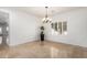 Stylish dining area featuring stone tile floors, a chandelier, and bright white walls and trim at 21804 N 38Th Pl, Phoenix, AZ 85050