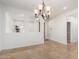 Elegant dining area with light stone tile floors, a decorative chandelier, and bright white walls and trim at 21804 N 38Th Pl, Phoenix, AZ 85050