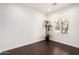 Bright, white living area featuring dark wood floors, fresh white trim and walls, with a plant near the window at 21804 N 38Th Pl, Phoenix, AZ 85050