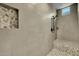 Walk-in shower with pebble-stone floor and tiled walls at 22897 E Carriage Way, Queen Creek, AZ 85142