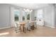 Sunlit dining room with minimalist decor, featuring a wooden table and floor-to-ceiling windows and natural lighting at 2560 E Thornton Ct, Gilbert, AZ 85297