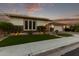 Charming single-story home at dusk with manicured landscaping and a two-car garage at 2560 E Thornton Ct, Gilbert, AZ 85297