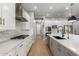 Well-lit modern kitchen with stainless steel appliances, large island, and sleek white cabinetry at 2560 E Thornton Ct, Gilbert, AZ 85297