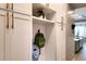 Mud room with white cabinets, shelving, and hooks, conveniently located near kitchen at 2560 E Thornton Ct, Gilbert, AZ 85297