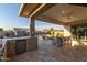 Inviting covered patio with an outdoor kitchen, dining set, and pool view at 2560 E Thornton Ct, Gilbert, AZ 85297