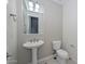 Guest bathroom with pedestal sink and toilet at 27831 N Makena Pl, Peoria, AZ 85383