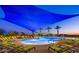 Evening view of resort-style pool with shade structures and lounge chairs at 27831 N Makena Pl, Peoria, AZ 85383